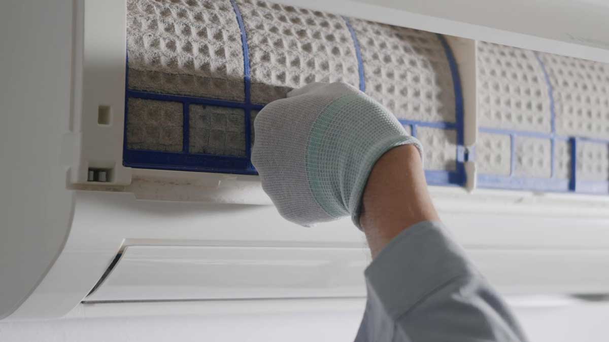 Image of a person cleaning a heat pump