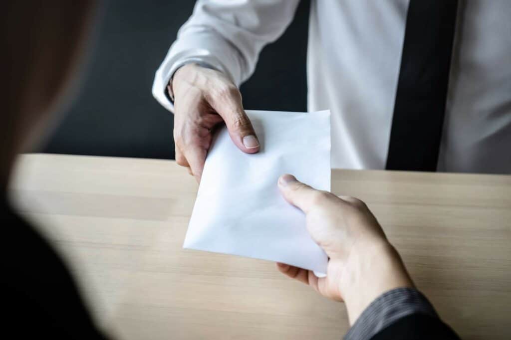 Photo of two people exchanging an envelope