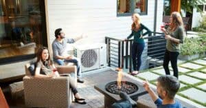 Groupe de personnes buvant un verre sur une terrasse a cote d’une thermopompe