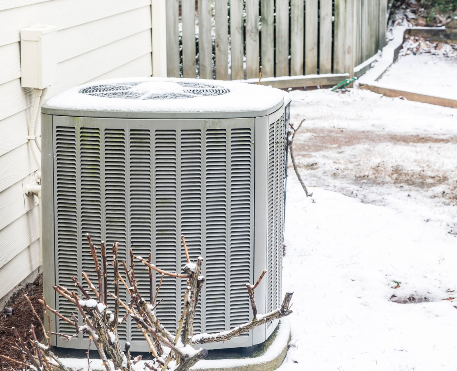 Une thermopompe située à l'extérieur et entourée de neige